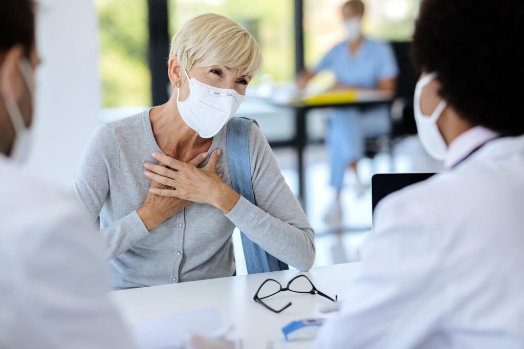 mature woman with face mask complains chest pain while talking doctor clinic 637285 9062